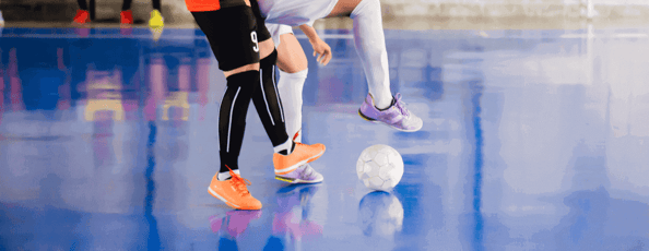 player trap and control of the ball to shoot a goal. Soccer players fighting each other by kicking the ball. Indoor soccer sports hall. Football futsal player, ball, futsal floor.